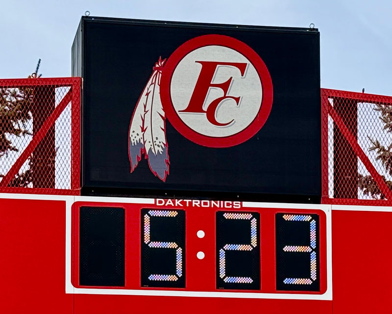 speaker with school logo above scoreboard